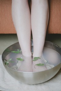 woman's feet in bucket with water 